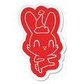 cute quirky cartoon sticker of a rabbit dancing wearing santa hat