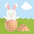 Cute rabbit with broken easter egg painted in the field Royalty Free Stock Photo