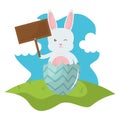 Cute rabbit with broken easter egg painted in the field