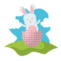 Cute rabbit with broken easter egg painted in the field Royalty Free Stock Photo