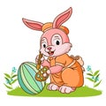 The cute rabbit is coloring the ester egg Royalty Free Stock Photo