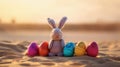 Cute rabbit toy and colorful painted easter eggs in the desert under sunshine. Shallow depth of field. Concept of happy easter day