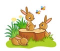 Cute rabbits sitting around the stump.