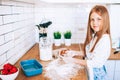 Cute red hair little girl making cooking in the kitchen. Flour. strawberry and eggs on the counter. Future occupation