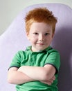 Cute red haired freckled little boy in green t-shirt waiting for doctor in medical office Royalty Free Stock Photo