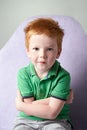 Cute red haired freckled little boy in green t-shirt waiting for doctor in medical office Royalty Free Stock Photo