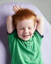 Cute red haired freckled little boy in green t-shirt waiting for doctor in medical office Royalty Free Stock Photo