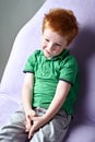 Cute red haired freckled little boy in green t-shirt waiting for doctor in medical office Royalty Free Stock Photo