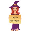 Cute red-haired witch with a pumpkin holding a piece of paper with happy halloween text. Royalty Free Stock Photo