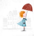 Cute red-head girl with umbrella in blue coat on city background.