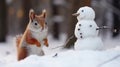 Cute red squirrel with small snowman in winter forest. Winter fun.