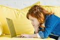 Cute redhead child using laptop