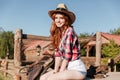 Cute redhead cowgirl sitting and resting on the ranch fence Royalty Free Stock Photo