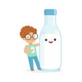 Cute redhead little boy and funny milk bottle with smiling human face playing and having fun, healthy childrens food