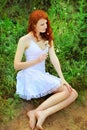 Cute redhead woman with dandelions.