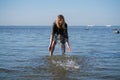 Attractive plus size woman in chiffon dress enjoys the shiny water in the blue sea