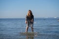 Attractive plus size woman in chiffon dress enjoys the shiny water in the blue sea