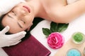 Cute relaxed young woman laying in spa salon with closed eyes Royalty Free Stock Photo