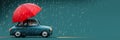 Cute retro car with red umbrella and heavy rain on teal background with copy space.