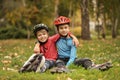 Cute roller skaters sitting on grass