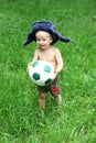 Cute Russian toddler boy in a ushanka hat is holding a soccer or