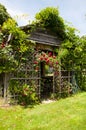 Cute rustic wood shed with rose rose trellis