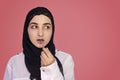 Cute 20s female putting lipstick with a brush. Beautiful Persian woman in hijab doing make-up applying lipstick on her lips Royalty Free Stock Photo