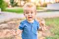 Cute and sad little boy crying having a tantrum at the park on a sunny day Royalty Free Stock Photo