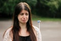 cute sad woman looking at banged blue balloon with crying emotion