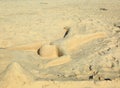 Cute sand sculpture representing a human laying on the beach with face down. Aruba island. Caribbean. Royalty Free Stock Photo