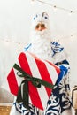 Cute santa claus gives a gift to the camera. Photo of kind Santa Claus giving xmas present and looking at camera Royalty Free Stock Photo