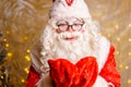 Cute santa claus in glasses on a wall background with a bright garland bokeh Royalty Free Stock Photo