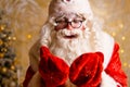 Cute santa claus in glasses on a wall background with a bright garland bokeh Royalty Free Stock Photo