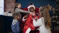 Cute santa claus in the hat opening bag with gifts for children.