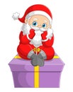 The cute santa claus is sitting and contemplating on the top of the big gift