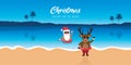 cute santa and deer with sunglasses on paradise beach summer christmas holiday Royalty Free Stock Photo