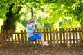 Cute school boy enjoying swing ride on playground Royalty Free Stock Photo