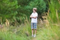 Cute school boy hiking in the woods in summer