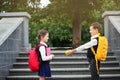 Cute school boy offering apple to girl with stationery Royalty Free Stock Photo