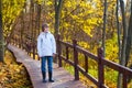 Cute school boy in park on wooden path way