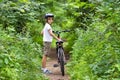 Cute school boy riding a bike in summer park Royalty Free Stock Photo