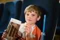 Cute school boy watching cartoon movie in the cinema. Leisure and activity for family with kids. Happy child with Royalty Free Stock Photo