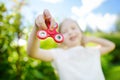 Cute school girl playing with fidget spinner on the playground. Popular stress-relieving toy for school kids and adults. Royalty Free Stock Photo