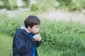 Cute School kid blowing dandelion flower in spring park while walking to school in the morning. Happy child boy having fun Royalty Free Stock Photo