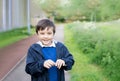 Cute School kid holding dandelion flower in spring park while walking to school in the morning. Happy child boy having fun Royalty Free Stock Photo