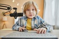 Cute schoolboy clicking mouse and pressing buttons of laptop keyboard Royalty Free Stock Photo