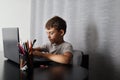 Focused Learning: Cute Schoolboy Engaged in Homework on Laptop