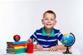 Cute schoolboy is writting isolated on a white background