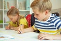 Cute schoolchildren are came back to school and learning at the table Royalty Free Stock Photo