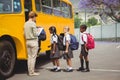 Cute schoolchildren waiting to get on school bus Royalty Free Stock Photo